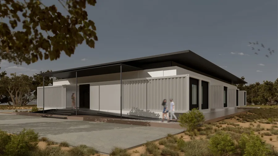 Render: compact clinic concept showing the single-building bar form with deep overhanging roof canopy, white container-derived walls, and arid landscape